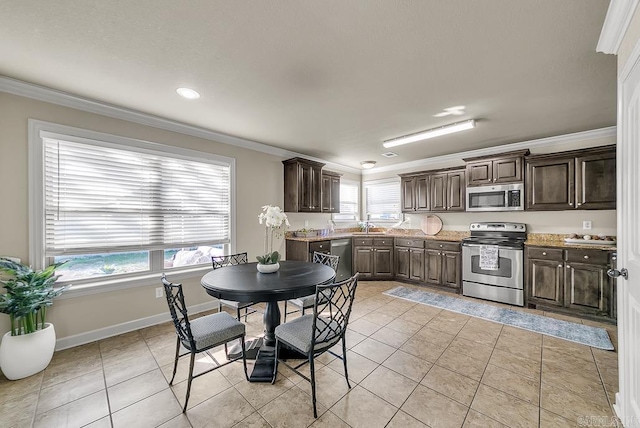 kitchen with a wealth of natural light, stainless steel appliances, dark brown cabinets, light tile patterned floors, and ornamental molding