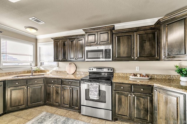 kitchen with sink, light tile patterned floors, ornamental molding, appliances with stainless steel finishes, and dark brown cabinets