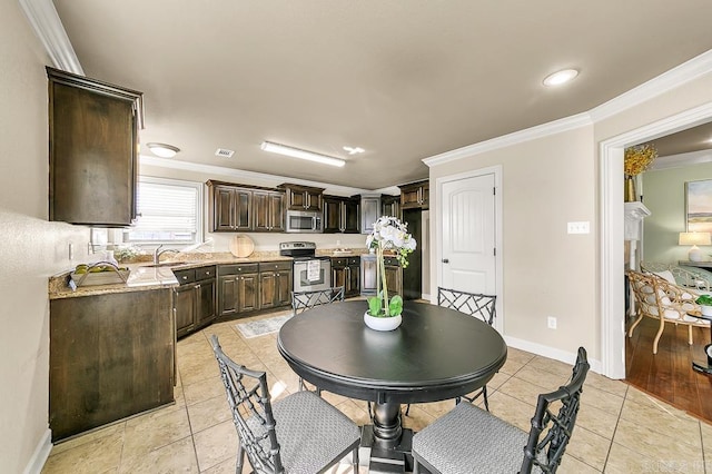 dining space with crown molding, sink, and light tile patterned flooring