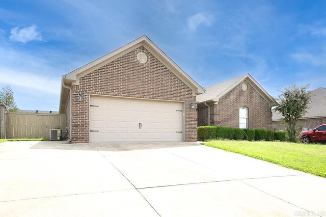 view of front of home with central AC unit, a garage, and a front lawn