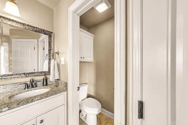 bathroom featuring tile patterned flooring, vanity, and toilet