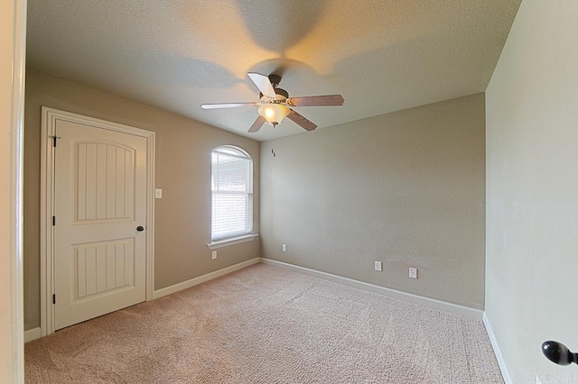 carpeted empty room with ceiling fan and a textured ceiling