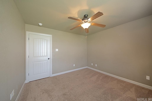 carpeted spare room with ceiling fan