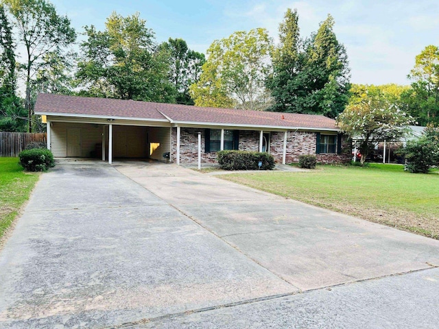 ranch-style home featuring a carport and a front lawn