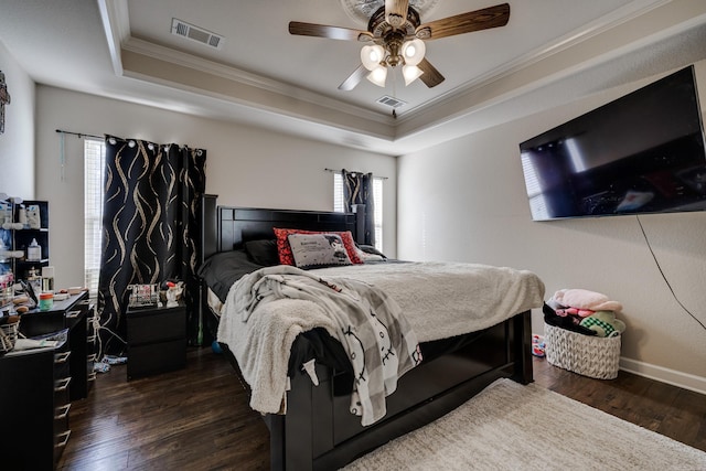 bedroom featuring ceiling fan, a tray ceiling, crown molding, and dark hardwood / wood-style floors