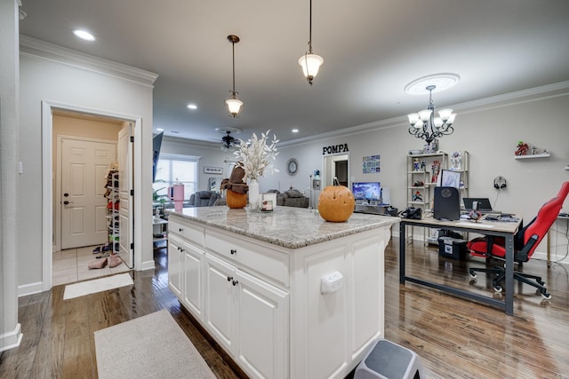 kitchen with decorative light fixtures, a center island, hardwood / wood-style flooring, and white cabinetry