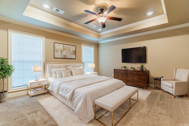 carpeted bedroom with a tray ceiling, ceiling fan, and crown molding