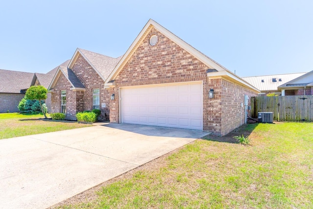 view of front of property featuring central AC, a front yard, and a garage