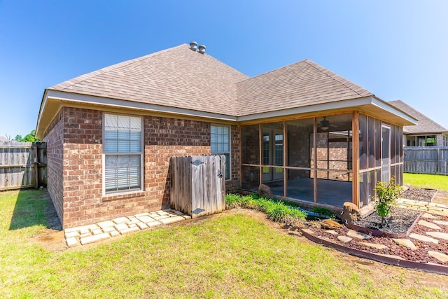 rear view of house featuring a sunroom and a yard