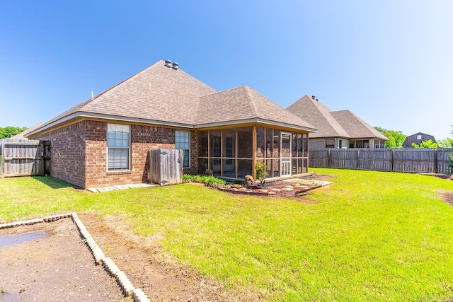 back of property with a lawn and a sunroom