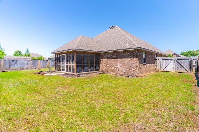 back of house featuring a sunroom and a yard