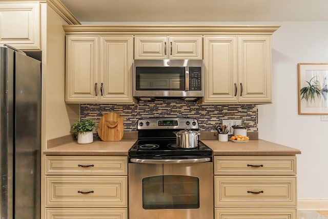 kitchen with backsplash, cream cabinets, and stainless steel appliances