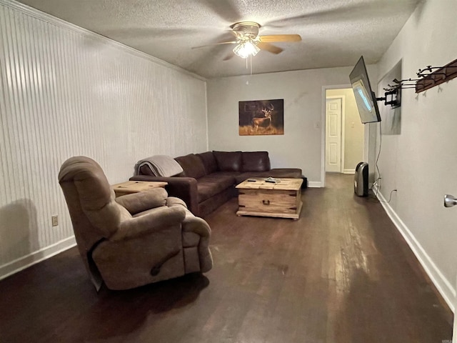 living room featuring ceiling fan, dark wood-type flooring, and a textured ceiling