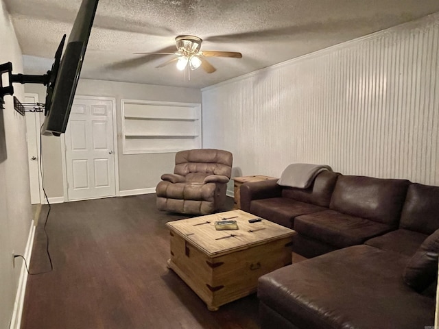 living room featuring dark hardwood / wood-style floors, ceiling fan, built in features, and a textured ceiling