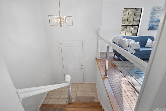 stairway featuring tile patterned flooring and an inviting chandelier