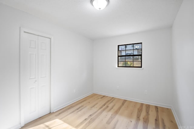 unfurnished bedroom with light hardwood / wood-style floors and a closet