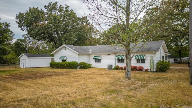 single story home with cooling unit and a front lawn