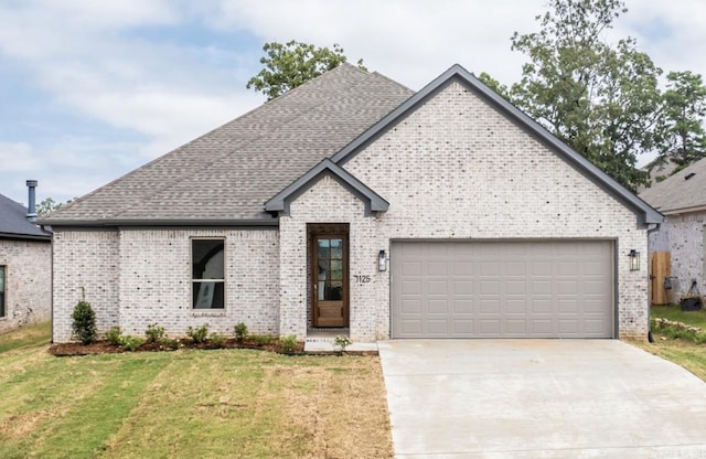 french country home with a garage and a front yard