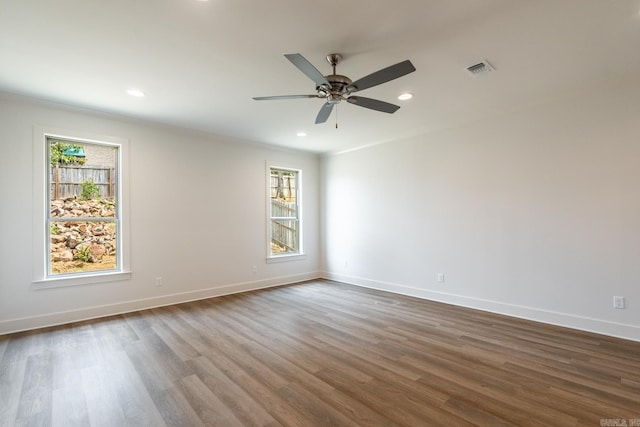 empty room with hardwood / wood-style flooring, a wealth of natural light, ornamental molding, and ceiling fan