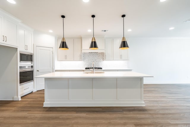 kitchen featuring white cabinetry, a kitchen island with sink, and stainless steel oven