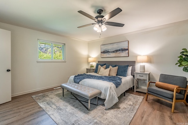 bedroom with ceiling fan, crown molding, and hardwood / wood-style flooring