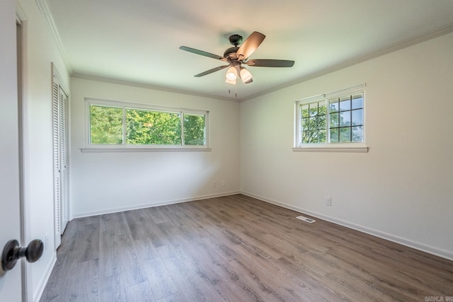 empty room featuring crown molding, ceiling fan, and light wood-type flooring