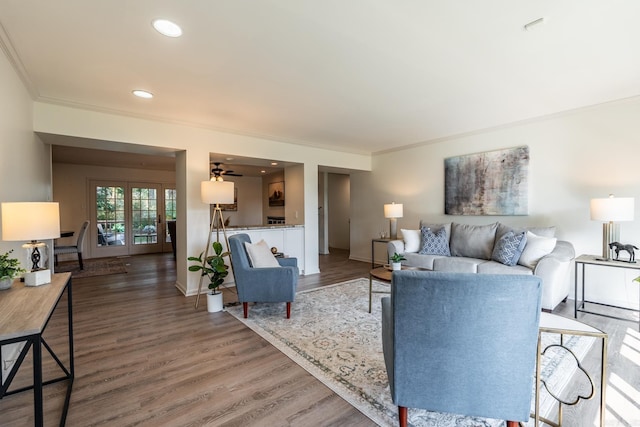 living room with crown molding, dark hardwood / wood-style flooring, and ceiling fan