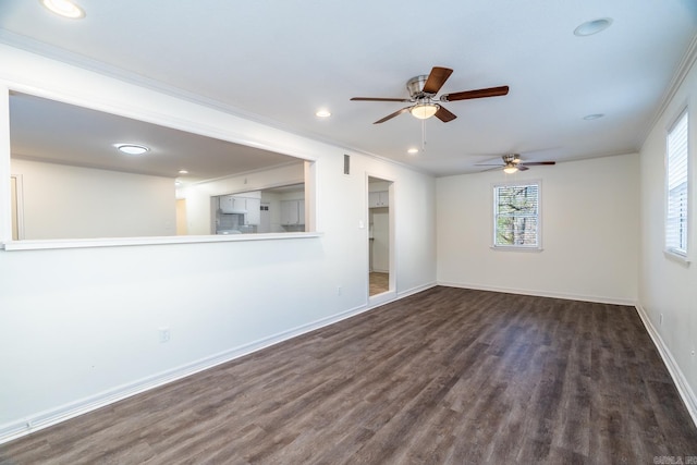 empty room with ceiling fan, crown molding, and dark wood-type flooring