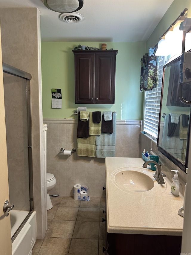 full bathroom featuring tile patterned floors, shower / bath combination with glass door, vanity, and toilet