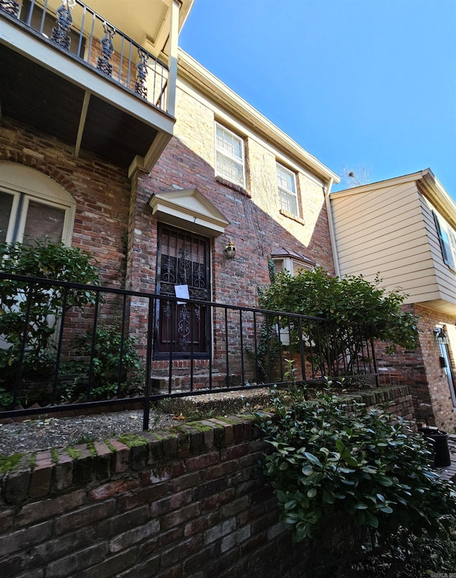 view of exterior entry featuring a balcony