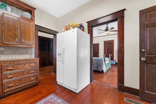 kitchen with tasteful backsplash, dark hardwood / wood-style flooring, ceiling fan, and white fridge with ice dispenser