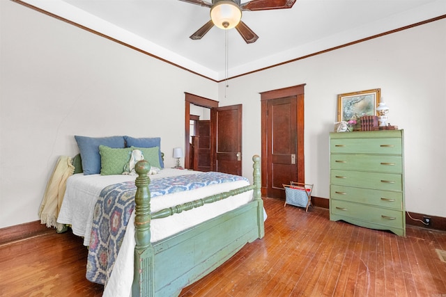 bedroom featuring ceiling fan, wood-type flooring, and ornamental molding