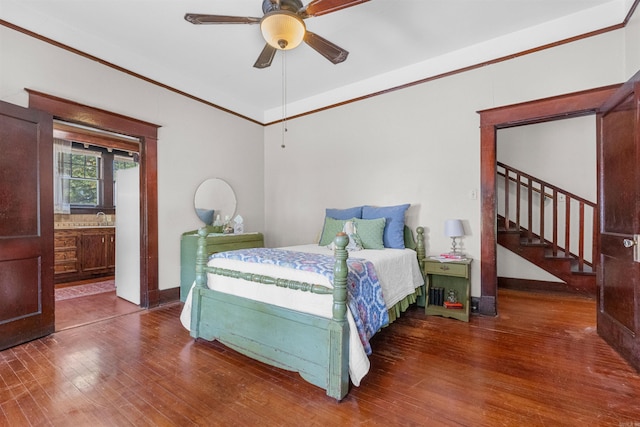 bedroom with ceiling fan, crown molding, wood-type flooring, and ensuite bathroom