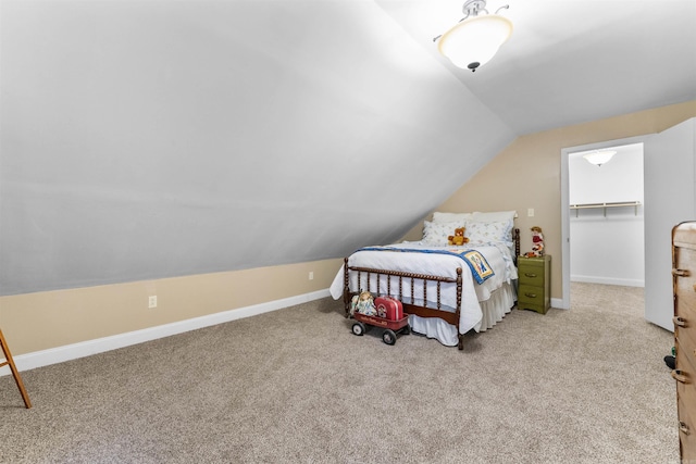 carpeted bedroom with a closet, a spacious closet, and vaulted ceiling