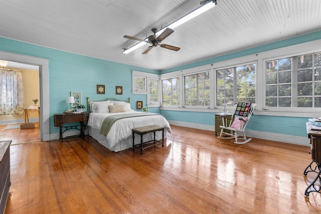 bedroom with connected bathroom, ceiling fan, and wood-type flooring