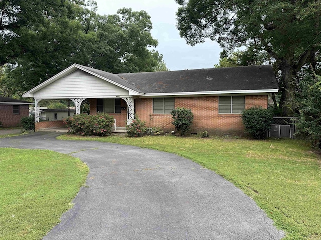 ranch-style home with a carport and a front lawn