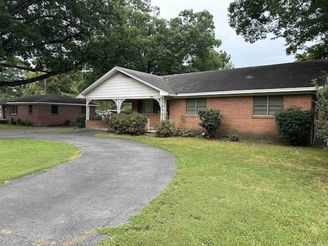 single story home with a front lawn and a carport