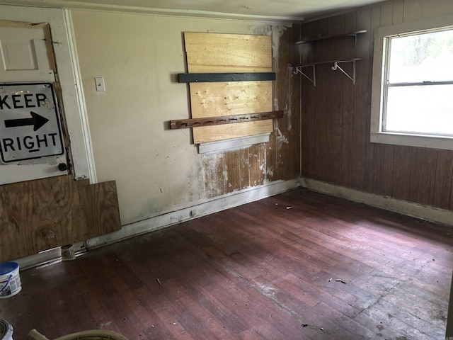 empty room featuring wooden walls and dark wood-type flooring