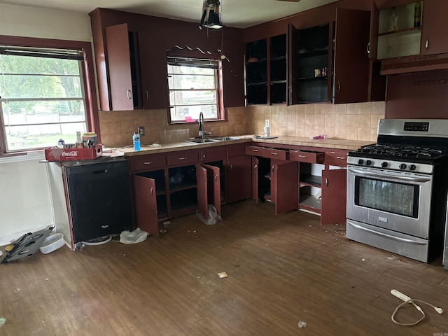 kitchen with exhaust hood, sink, stainless steel gas range, hardwood / wood-style flooring, and tasteful backsplash