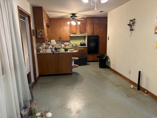 kitchen featuring black oven, ceiling fan, kitchen peninsula, and a breakfast bar