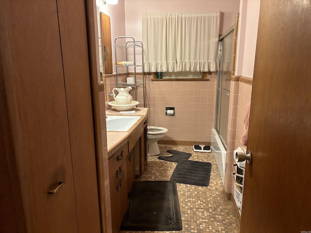 full bathroom with vanity, shower / bath combination with glass door, tile patterned flooring, toilet, and tile walls