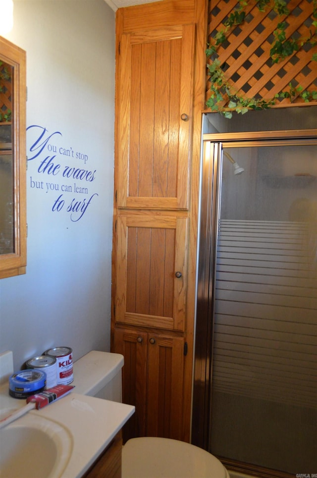 bathroom with vanity, a shower with shower door, and toilet