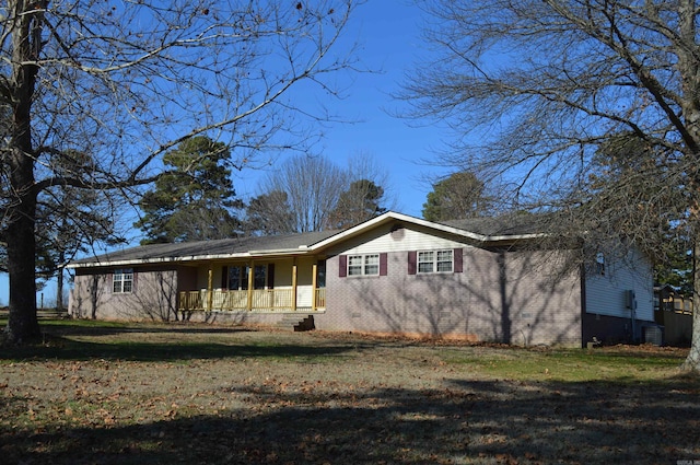 rear view of property featuring covered porch and a lawn