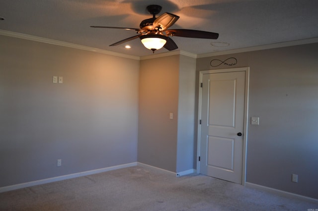 spare room featuring light carpet, ceiling fan, and crown molding