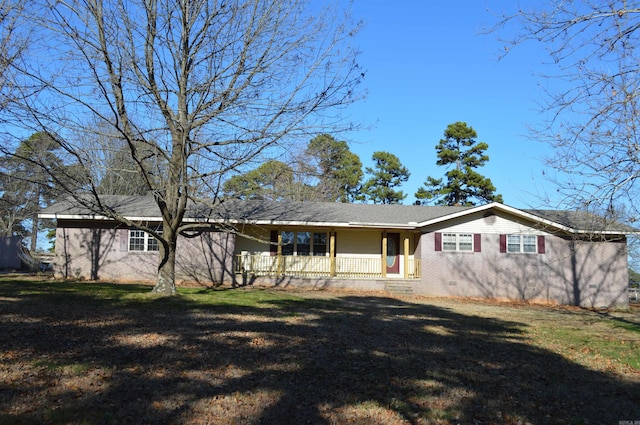 back of property with covered porch and a yard