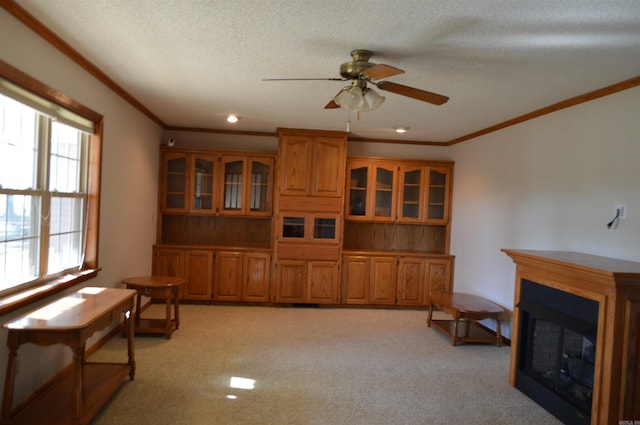 interior space with light carpet, ceiling fan, and crown molding