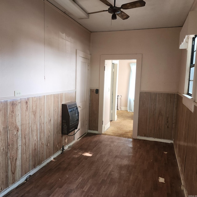 unfurnished room with wood-type flooring, heating unit, and ceiling fan