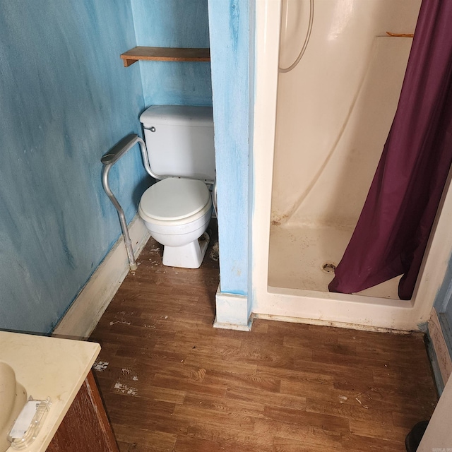 bathroom featuring curtained shower, vanity, wood-type flooring, and toilet