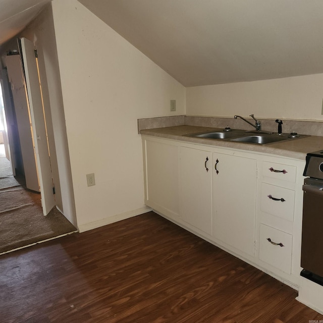 kitchen featuring white cabinetry, sink, dark wood-type flooring, and vaulted ceiling