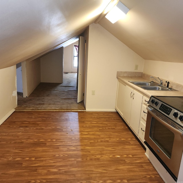 kitchen with stainless steel range with electric stovetop, lofted ceiling, white cabinets, sink, and light wood-type flooring